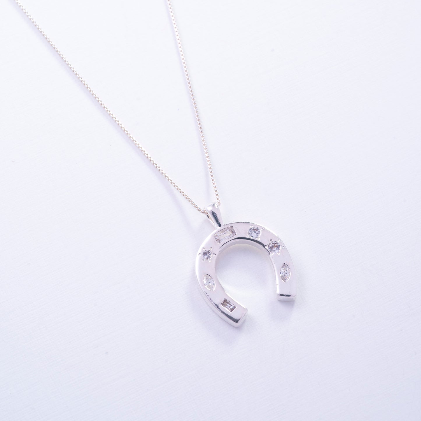 Dije de herradura con circones en Plata