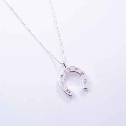 Dije de herradura con circones en Plata